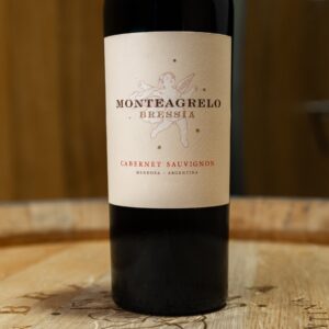 Botella de vino tinto Monteagrelo Cabernet Sauvignon de bodega Bressia, apoyada sobre una barrica de madera.