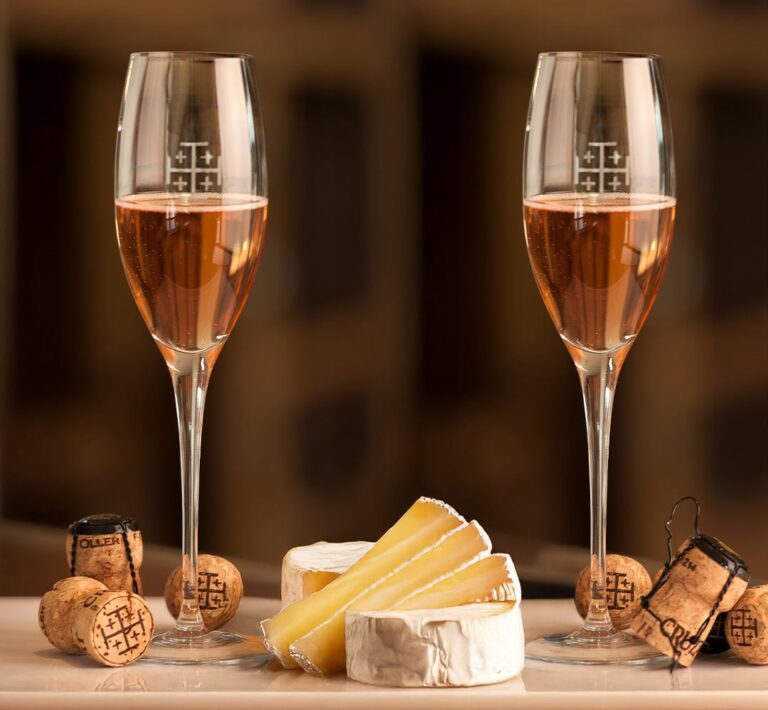 Dos copas de espumante rosado Cruzat Cuvée Rosé Extra Brut junto a una selección de quesos.